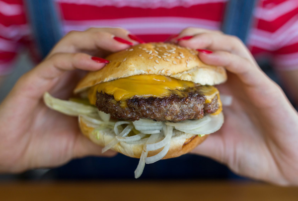 Woman eating a cheeseburger.