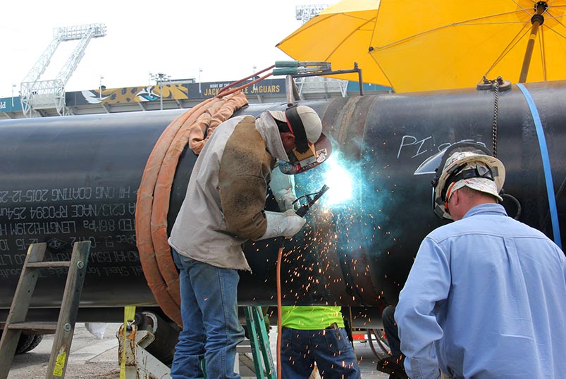 Welding crew joining pipe sections