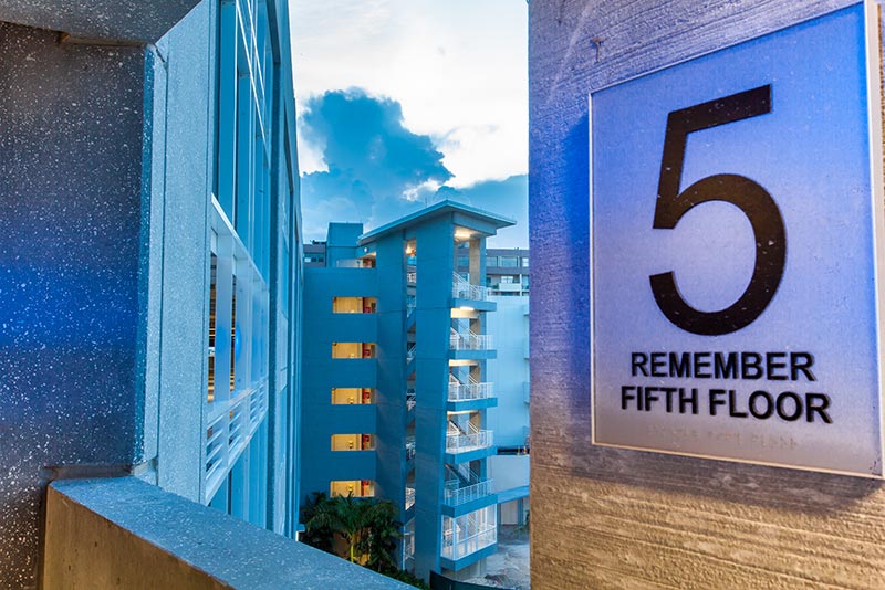 Looking through window from inside parking garage. Number 5 wayfinding sign in view.